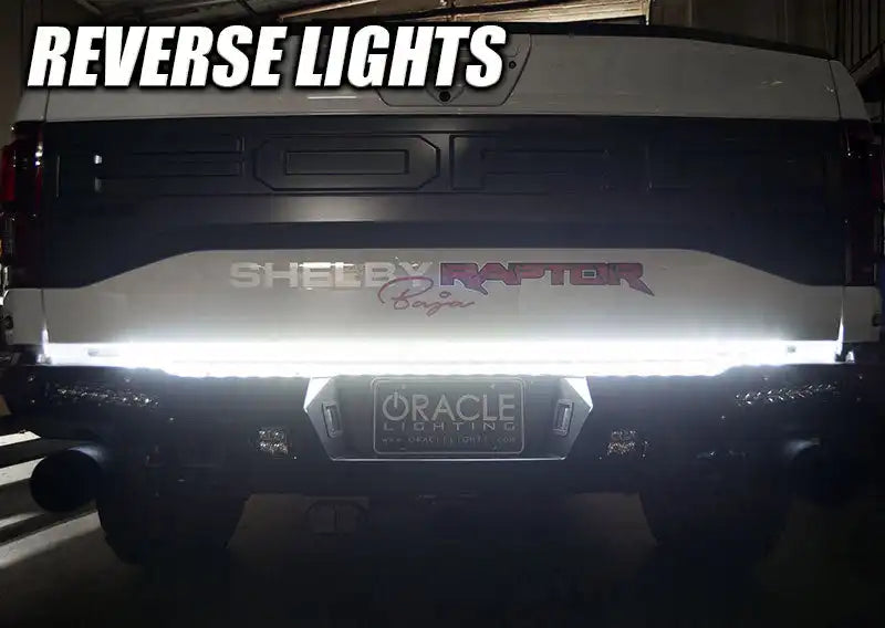 Rear view of a Ford Raptor with 60" Double Row LED Truck Tailgate Light Bar installed and reverse lights on.