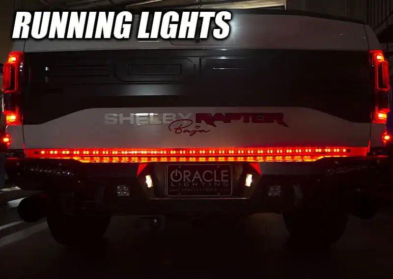 Rear end of a Ford Raptor with 60" Double Row LED Truck Tailgate Light Bar installed and running lights on.