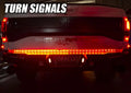 Rear view of a Ford Raptor with 60" Double Row LED Truck Tailgate Light Bar installed and turn signal on.