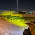 View from the driver's side of a Jeep, showing the light beam from the LED Integrated Skit Plate shining into the distance.