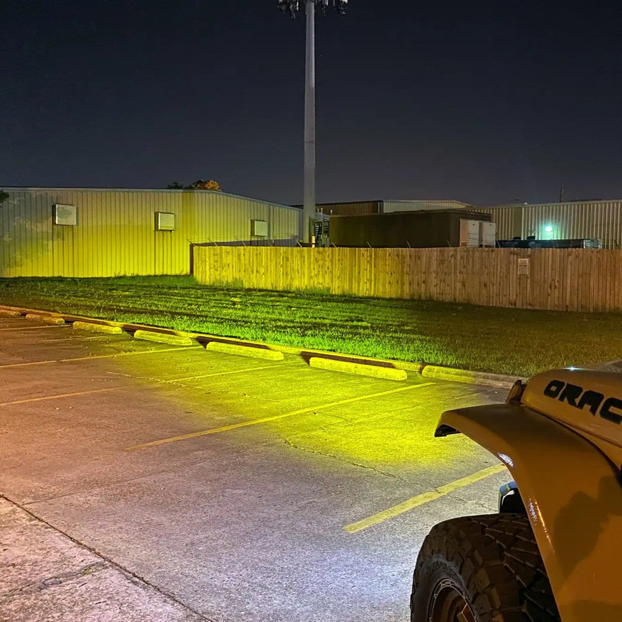 View from the driver's side of a Jeep, showing the light beam from the LED Integrated Skit Plate shining into the distance.