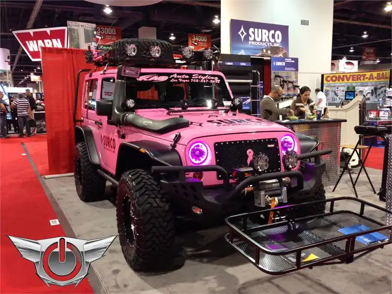 Pink Jeep in a showroom with pink LED headlight halo rings installed.