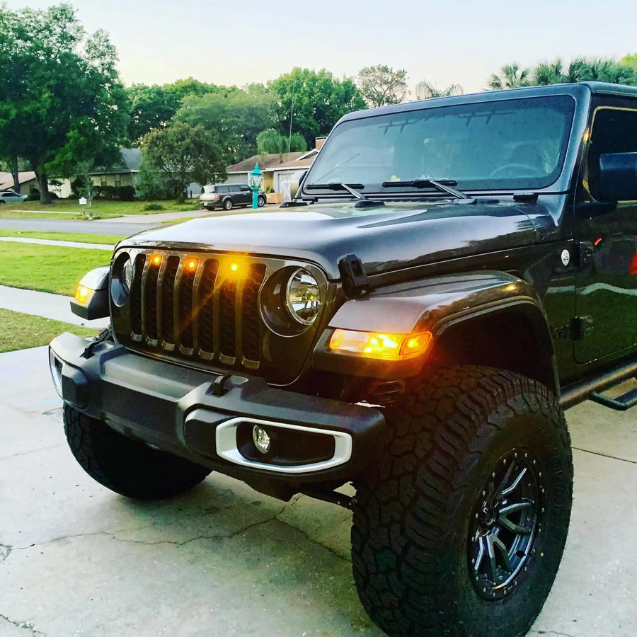 Front end of a Jeep Wrangler JL with amber Pre-Runner Style LED Grill Light Kit installed.