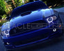 Front end of a Ford Mustang with white LED headlight and fog light halo rings.