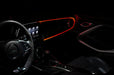 Car interior with red fiber optic lighting installed on the dashboard.