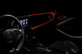 Car interior with red fiber optic lighting installed on the dashboard.