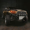 Bronze Toyota truck with large off-road tires in a dark setting