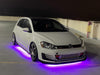 White Volkswagen on a rooftop parking garage with purple LED underbody kit.