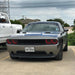 Front end of a silver Dodge Challenger with red LED headlight halo rings installed.