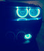 Close-up of cyan LED headlight and fog light halo rings installed on a Dodge Challenger.