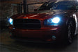 Front end of a Dodge Charger with very bright headlight bulbs.