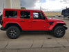 Side view of a red Jeep with Sidetrack™ LED Lighting System installed.