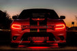 Front end of a red Dodge Charger with red headlight DRLs.
