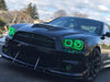 Close-up on the front end of a black Dodge Charger, with green LED headlight halo rings installed.