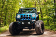 Front end of a Jeep Wrangler JK with white LED headlight and fog light halos installed.