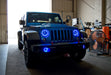 Three quarters view of a Jeep Wrangler JK with blue LED headlight and fog light halos installed.