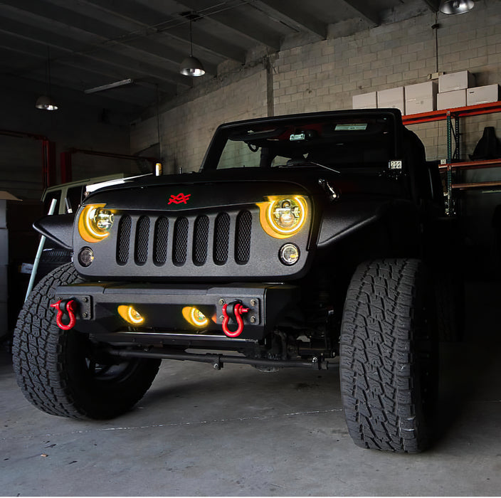 Front end of a Jeep Wrangler JK with yellow LED headlight and fog light halos installed.