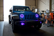 Three quarters view of a Jeep Wrangler JK with purple LED headlight and fog light halos installed.