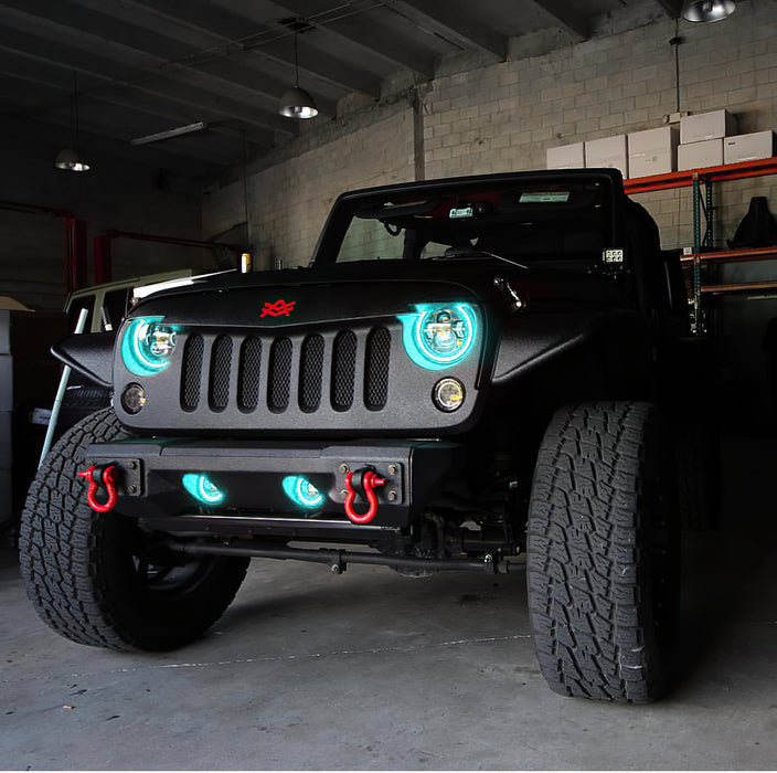 Front end of a Jeep Wrangler JK with cyan LED headlight and fog light halos installed.