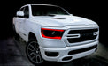 Three quarters view of a white Dodge RAM 1500 with read headlight DRLs installed.