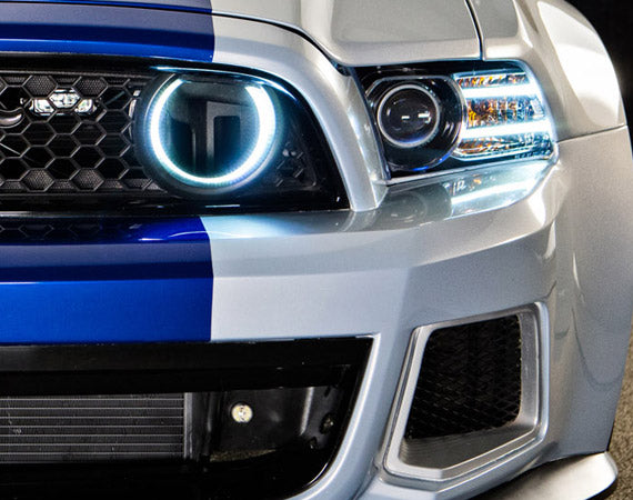 Close-up on a Ford Mustang grill with Surface Mount Fog Light Halos installed.