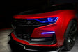 Front end of a red Chevrolet Camaro with blue headlight DRLs.