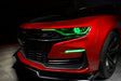 Front end of a red Chevrolet Camaro with green headlight DRLs.