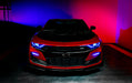 Front view of a red Chevrolet Camaro with blue headlight and fog light DRLs.