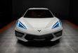Front view of a white C8 Corvette with cyan headlight DRLs.