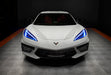Front view of a white C8 Corvette with blue headlight DRLs.