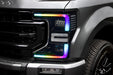 Close-up of a Ford Superduty headlight with rainbow DRLs.