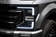 Close-up of a Ford Superduty headlight with white DRLs.