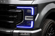 Close-up of a Ford Superduty headlight with blue DRLs.