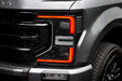 Close-up of a Ford Superduty headlight with red DRLs.