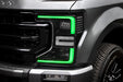 Close-up of a Ford Superduty headlight with green DRLs.