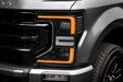 Close-up of a Ford Superduty headlight with amber DRLs.
