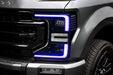 Close-up of a Ford Superduty headlight with purple DRLs.