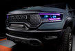 Front end of a Ram 1500 with purple headlight DRLs and cyan demon eye projectors.