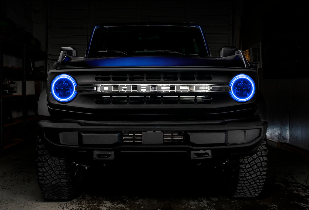 Front view of a blue Ford Bronco with blue headlight halos.
