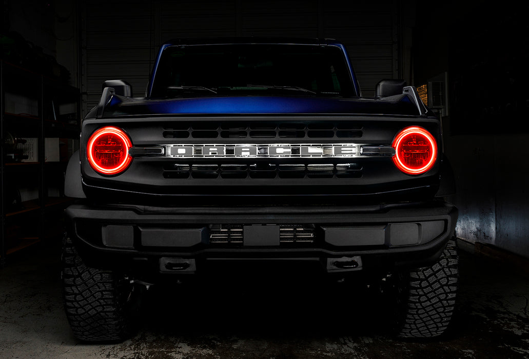 Front view of a blue Ford Bronco with red headlight halos.