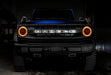 Front view of a blue Ford Bronco with amber headlight halos.