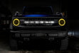 Front view of a blue Ford Bronco with yellow headlight halos.