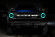 Front view of a blue Ford Bronco with cyan headlight halos.