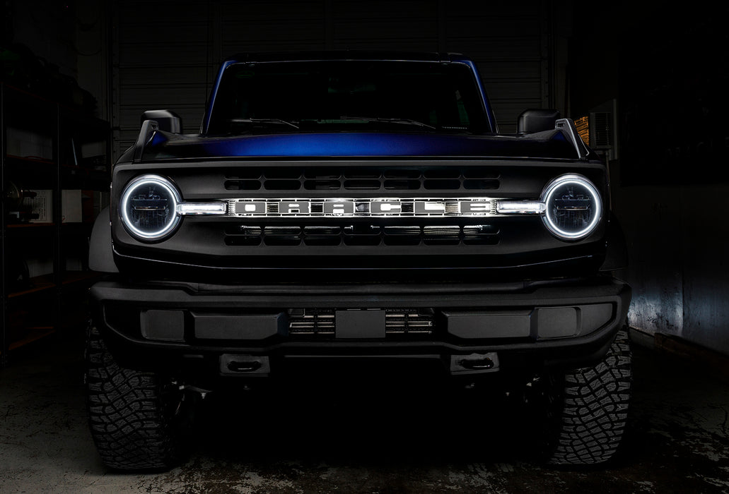 Front view of a blue Ford Bronco with white halos and DRLs.