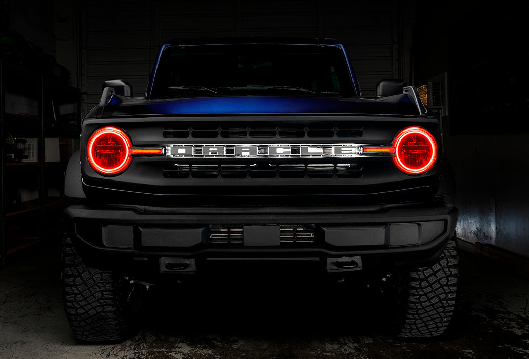 Front view of a blue Ford Bronco with red halos and DRLs.