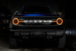 Front view of a blue Ford Bronco with amber halos and DRLs.
