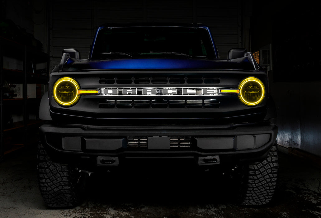 Front view of a blue Ford Bronco with yellow halos and DRLs.