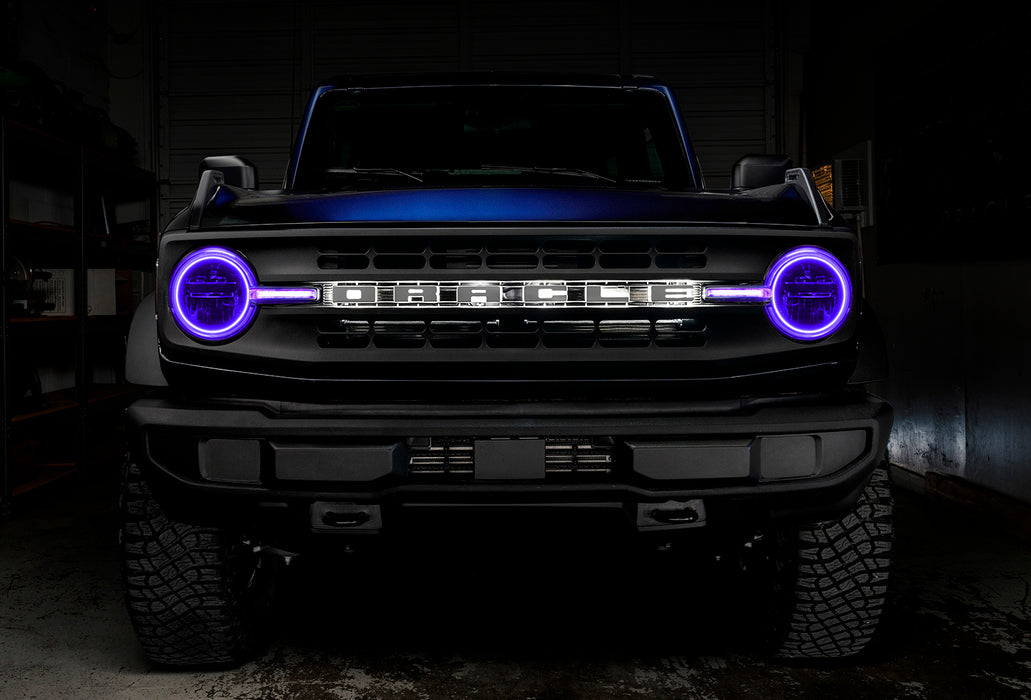 Front view of a blue Ford Bronco with purple halos and DRLs.
