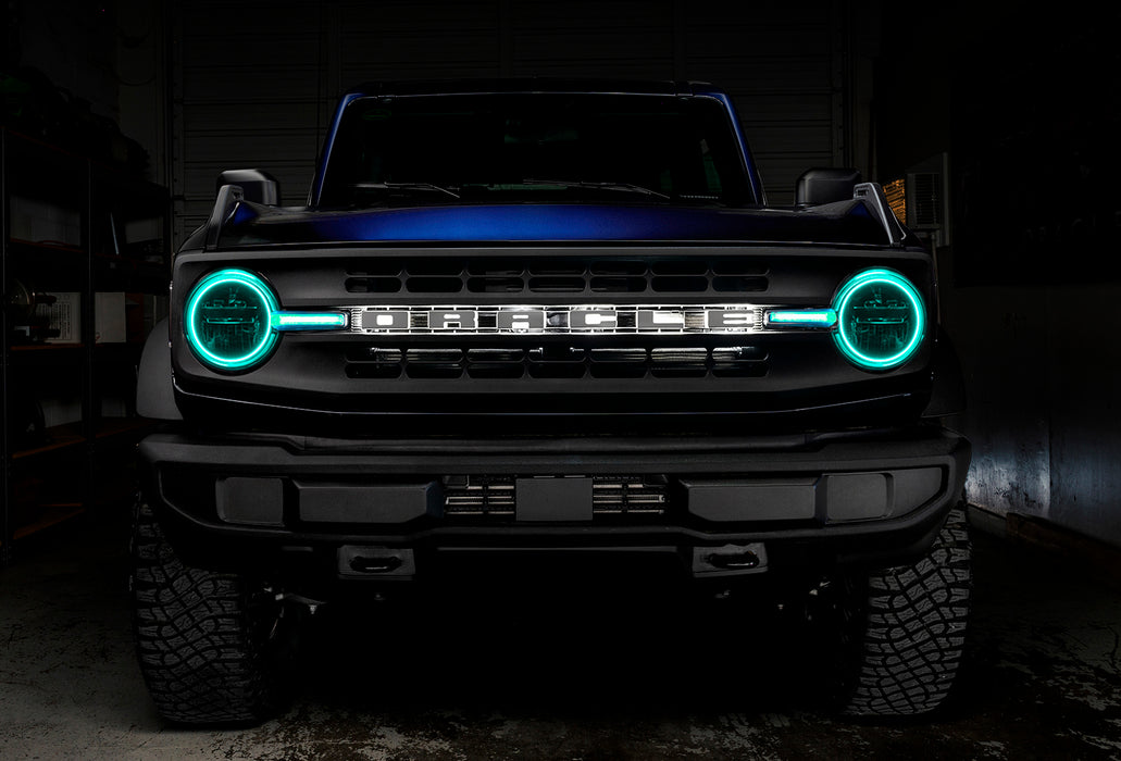 Front view of a blue Ford Bronco with cyan halos and DRLs.
