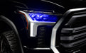 Close-up of a 2022+ Toyota Tundra headlight module installed with blue demon eye projector.